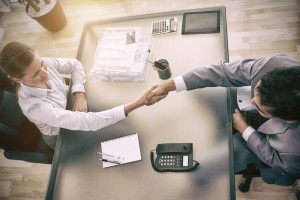 Above view of young consultant shaking hands with customer