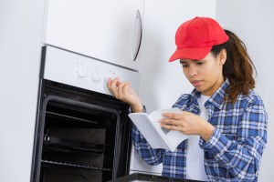 Woman reading instructions for new oven