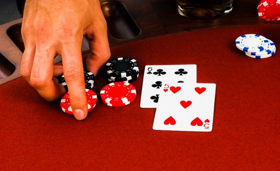 Close up detail of the hand of a man placing a double down bet in a blackjack game in Las Vegas