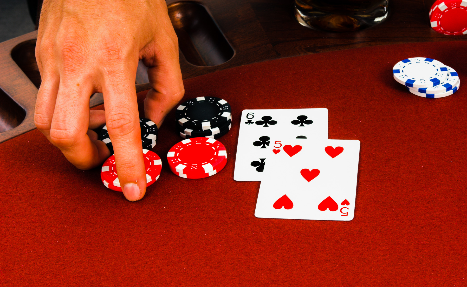 Close up detail of the hand of a man placing a double down bet in a blackjack game in Las Vegas